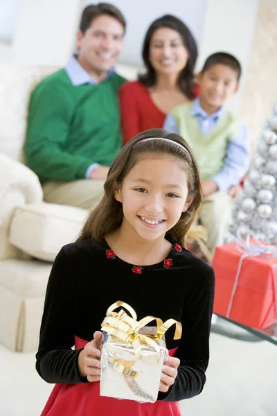 Jong Meisje Staande Bedrijf Kerstcadeau Met Haar Ouders Een — Stockfoto