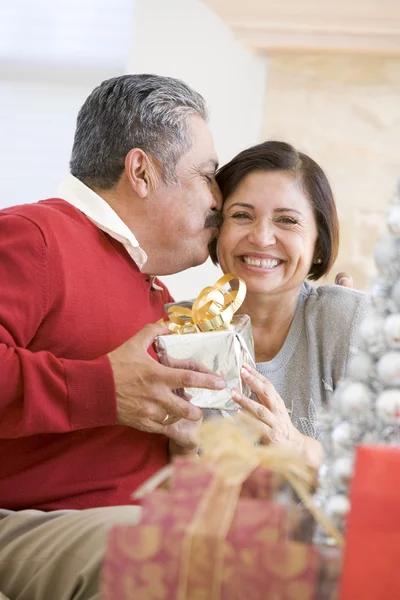 Paar mittleren Alters sitzt liebevoll und hält Weihnachten — Stockfoto