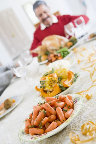Stoły obiadowe, dania świąteczne, z mężczyzną w tle carvin — Zdjęcie stockowe