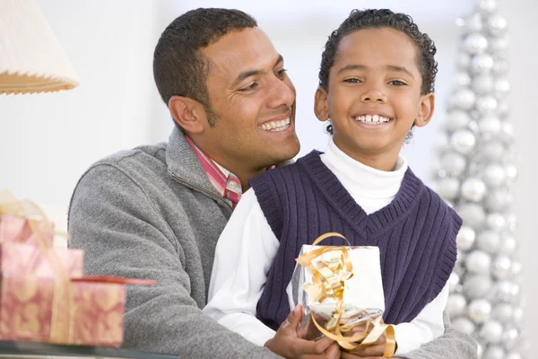 Otec a syn objímání, drží vánoční dárek — Stock fotografie