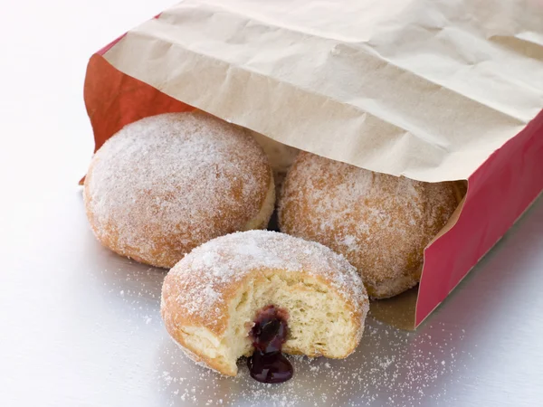 Tüte Himbeer-Marmelade-Donuts mit Biss genommen — Stockfoto