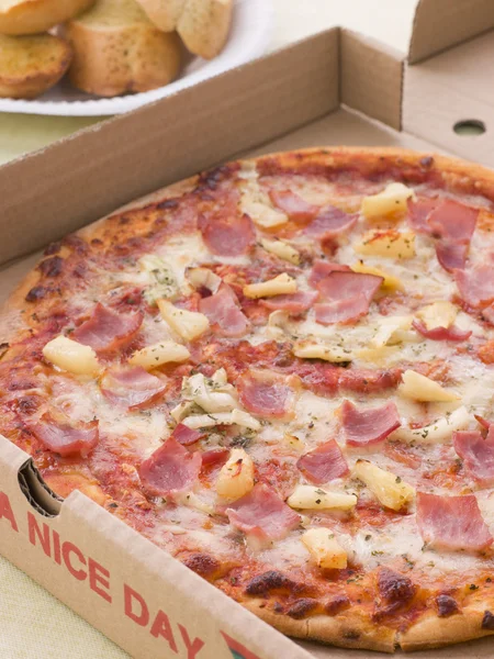 Hawaiianische Pizza im Take-away-Karton mit Knoblauchbrot — Stockfoto