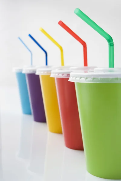Rangée de béchers à boissons gazeuses colorés avec des pailles — Photo