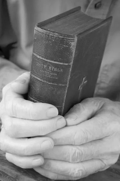 Vieilles mains tenant la Bible usée — Photo