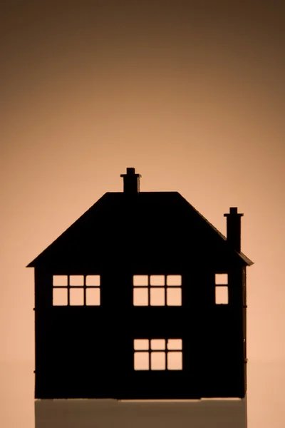 Hus form mot orange bakgrund — Stockfoto