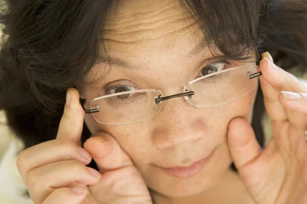 Γυναίκα που ψάχνει μέσω νέα γυαλιά — Φωτογραφία Αρχείου