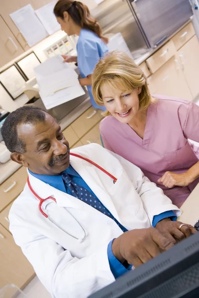 Lekarz i pielęgniarka dyskusji coś w recepcji — Zdjęcie stockowe