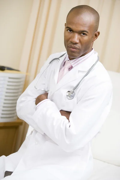 Lekarz siedzi na łóżku szpitalnym — Zdjęcie stockowe