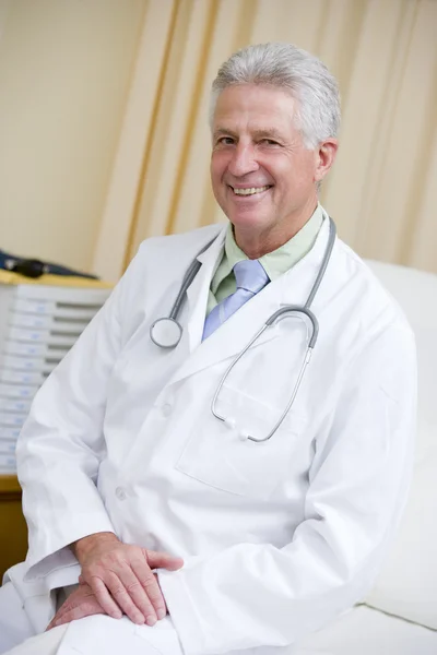 Доктор, сидящий на больничной койке — стоковое фото