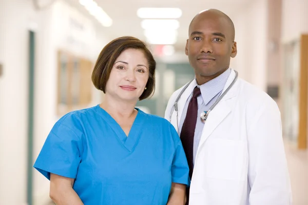 Врач и медсестра, стоящие в больничном коридоре — стоковое фото