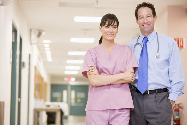 Врач и медсестра стоят в больничном коридоре — стоковое фото