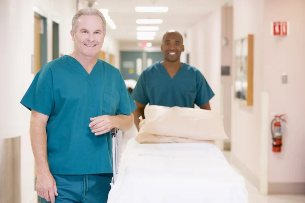Twee Helpers Duwen Een Lege Bed Door Een Ziekenhuis Gang — Stockfoto