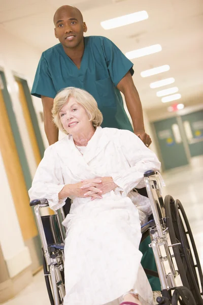 有序推进一个高级的女人坐在轮椅上下来医院 — 图库照片