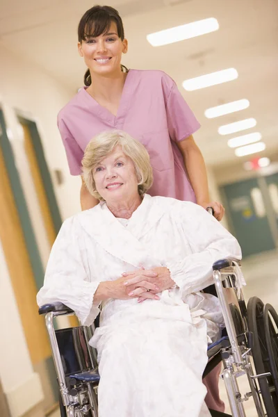 一名护士推一个高级的女人坐在轮椅上下来医院 — 图库照片