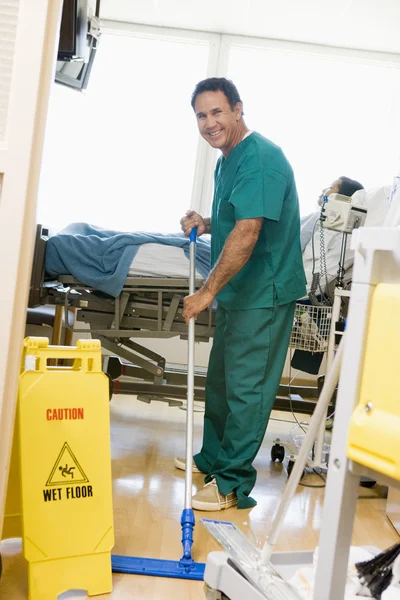 Uma ordenada a vasculhar o chão numa ala do hospital — Fotografia de Stock