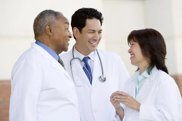 Trzech lekarzy, stojący poza szpitalem — Zdjęcie stockowe