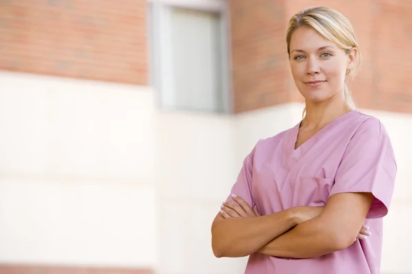 Pielęgniarka stojący poza szpitalem — Zdjęcie stockowe