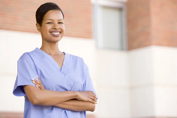 Медсестра, стоящая возле больницы — стоковое фото