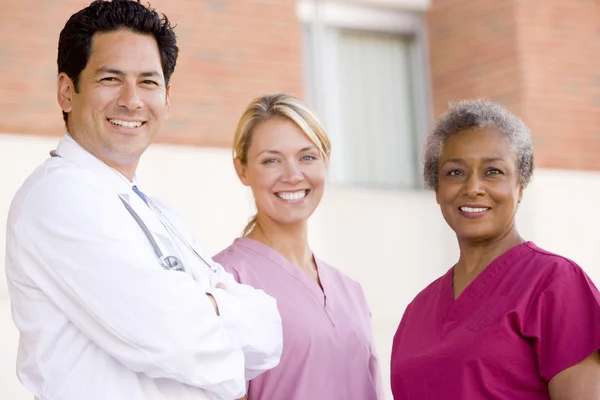 Lékaře a sestry, stojící mimo nemocnici — Stock fotografie