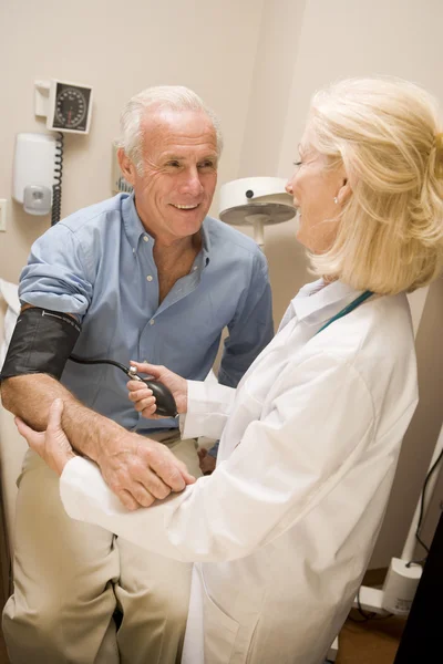 Arzt überprüft Blutdruck des Mannes — Stockfoto