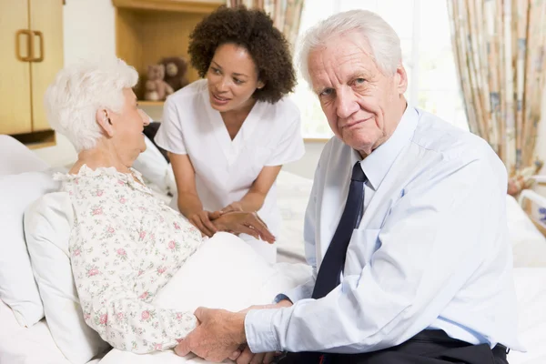 Krankenschwester spricht mit Senioren-Paar — Stockfoto