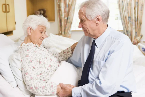 Старший мужчина навещает свою жену в больнице — стоковое фото