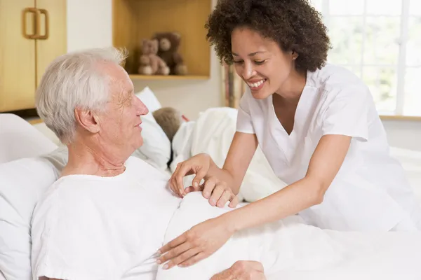 Sjuksköterskan att hjälpa äldre man — Stockfoto