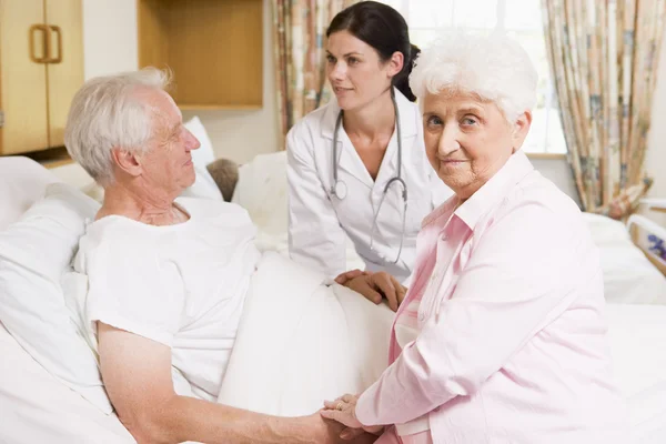 Arzt im Gespräch mit Senioren-Paar — Stockfoto