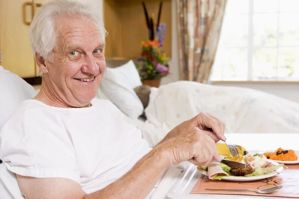 Starší člověk jíst nemocniční jídlo v bad — Stock fotografie