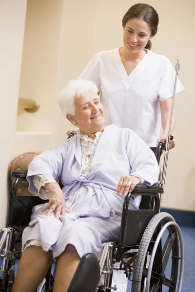 护士推女人坐在轮椅上 — 图库照片