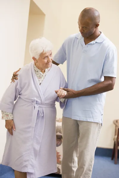Sjuksköterskan att hjälpa äldre kvinna att gå — Stockfoto