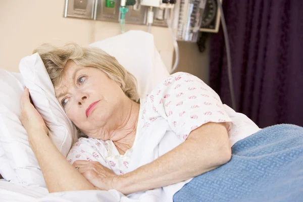 高级女人躺在医院的床上 — 图库照片