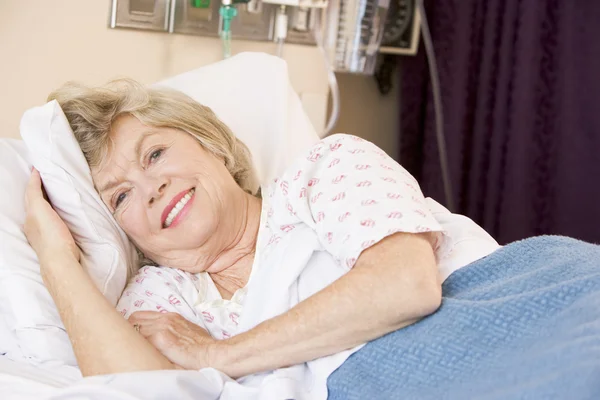 Старшая женщина лежит в больничной кровати — стоковое фото