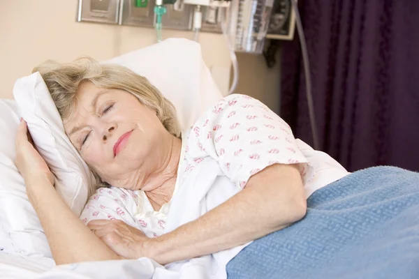 病院のベッドで眠っている年配の女性 — ストック写真