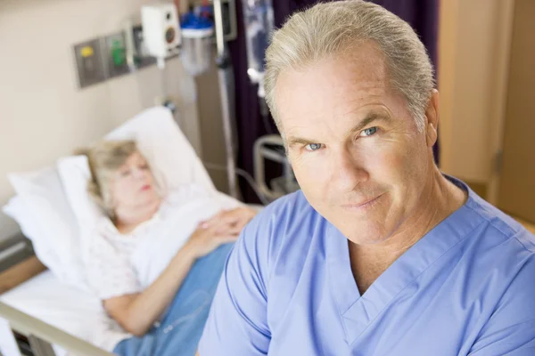 Hasta odasında duruyorsun, ciddi görünümlü doktor — Stok fotoğraf