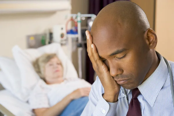 Doktor vypadal unavený a frustrovaný v nemocničním pokoji — Stock fotografie