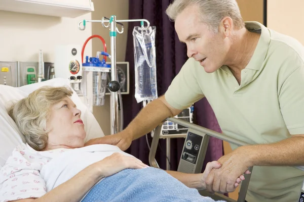 Mellersta åldern man besöker sin mor på sjukhus — Stockfoto