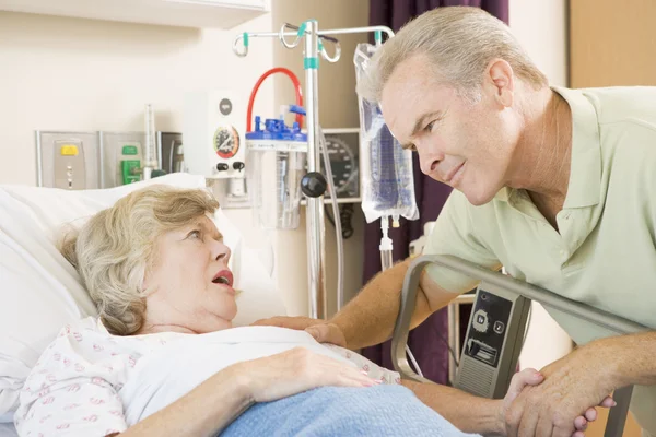Mellersta åldern man pratar med äldre kvinna på sjukhus — Stockfoto