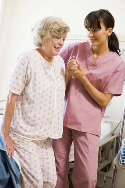 Enfermera ayudando a mujer mayor a caminar — Foto de Stock