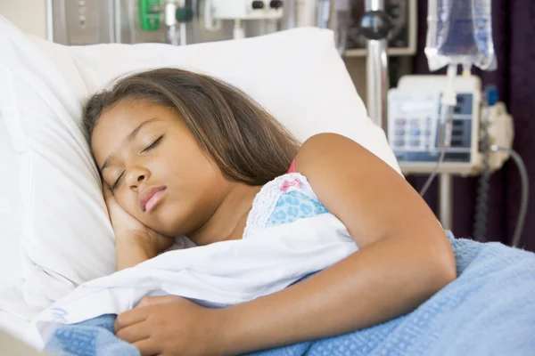 Joven chica durmiendo en cama de hospital — Foto de Stock