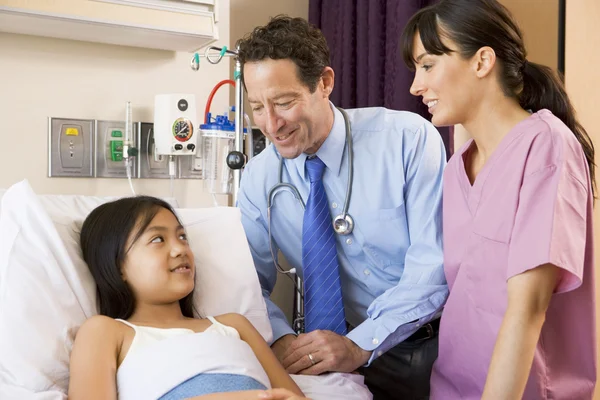 Lekarz i pielęgniarka mówi do dziewczyny — Zdjęcie stockowe