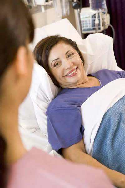 Senior vrouw liggen in ziekenhuisbed, glimlachend — Stockfoto