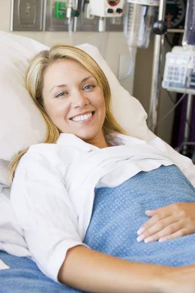 女性は笑みを浮かべて 病院のベッドで横になっています — ストック写真
