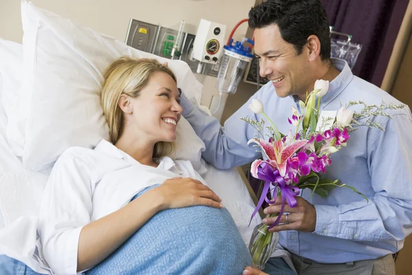 Mannen ger sin gravida fru blommor — Stockfoto