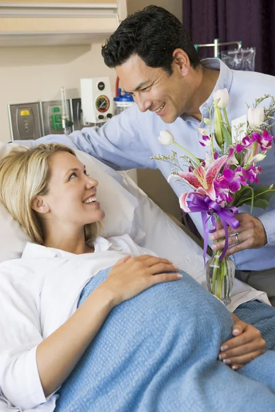 Homem dando sua esposa grávida flores — Fotografia de Stock