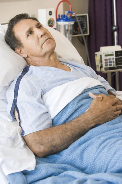Μέσης ηλικίας άνθρωπο ξαπλωμένη στο κρεβάτι του νοσοκομείο — Φωτογραφία Αρχείου