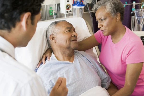 Para starszy mówi do lekarza, patrząc martwi — Zdjęcie stockowe