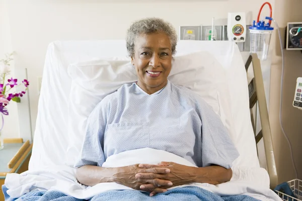 Ανώτερος γυναίκα που κάθεται στο κρεβάτι του νοσοκομείο — Φωτογραφία Αρχείου