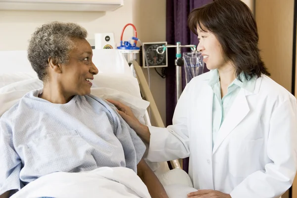 Läkare pratar med äldre kvinna — Stockfoto