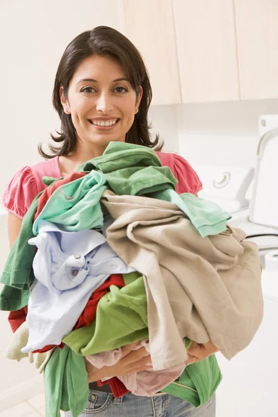 Kvinna anläggning hög med tvätt — Stockfoto